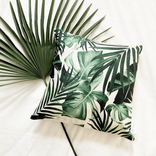 Our Rainforest Collection of Water-Resistant Outdoor Throw Pillowcase with beautiful lifelike 3D image of a 'mix of palm and monstera leafs' on an off-white background